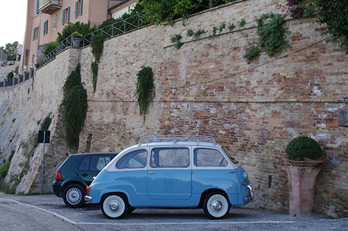 A vintage Fiat parked on an Italian street corner