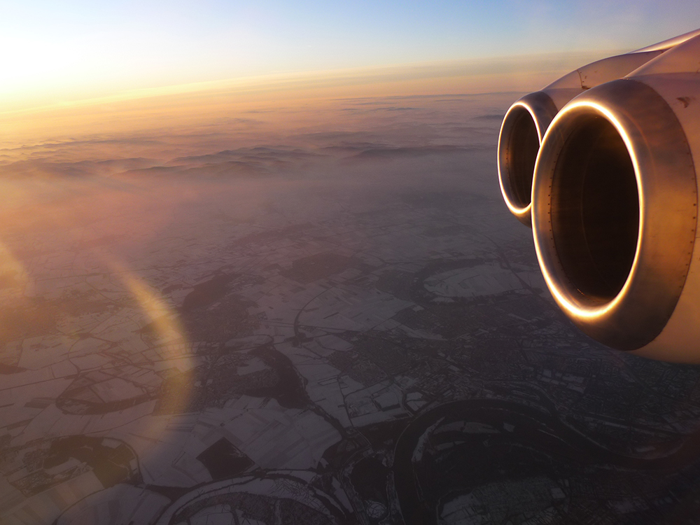 From the window of a plane flying through a dusk sky — somewhere along the journey