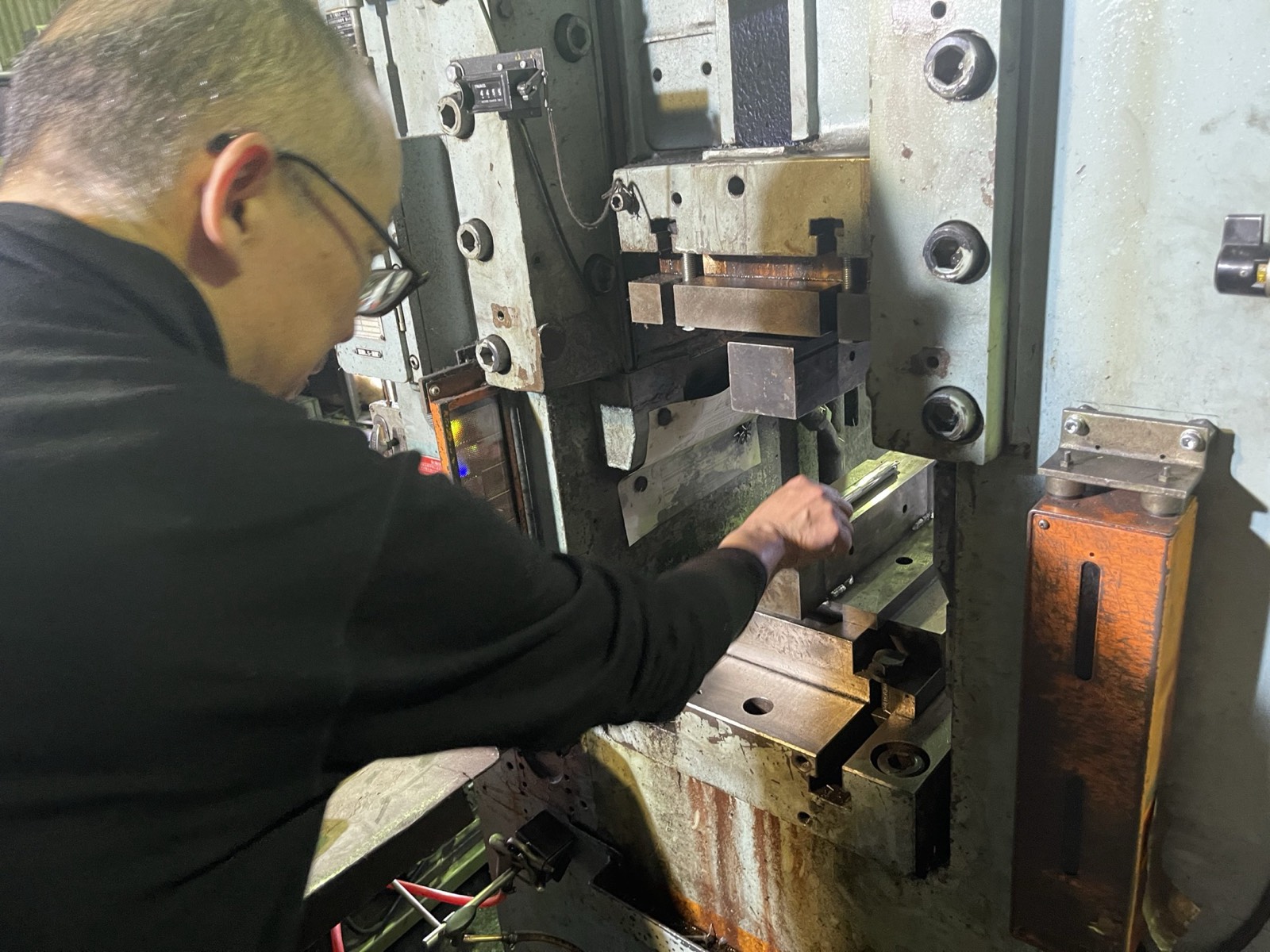 A craftsman forming an ISAJIG on the large press machine