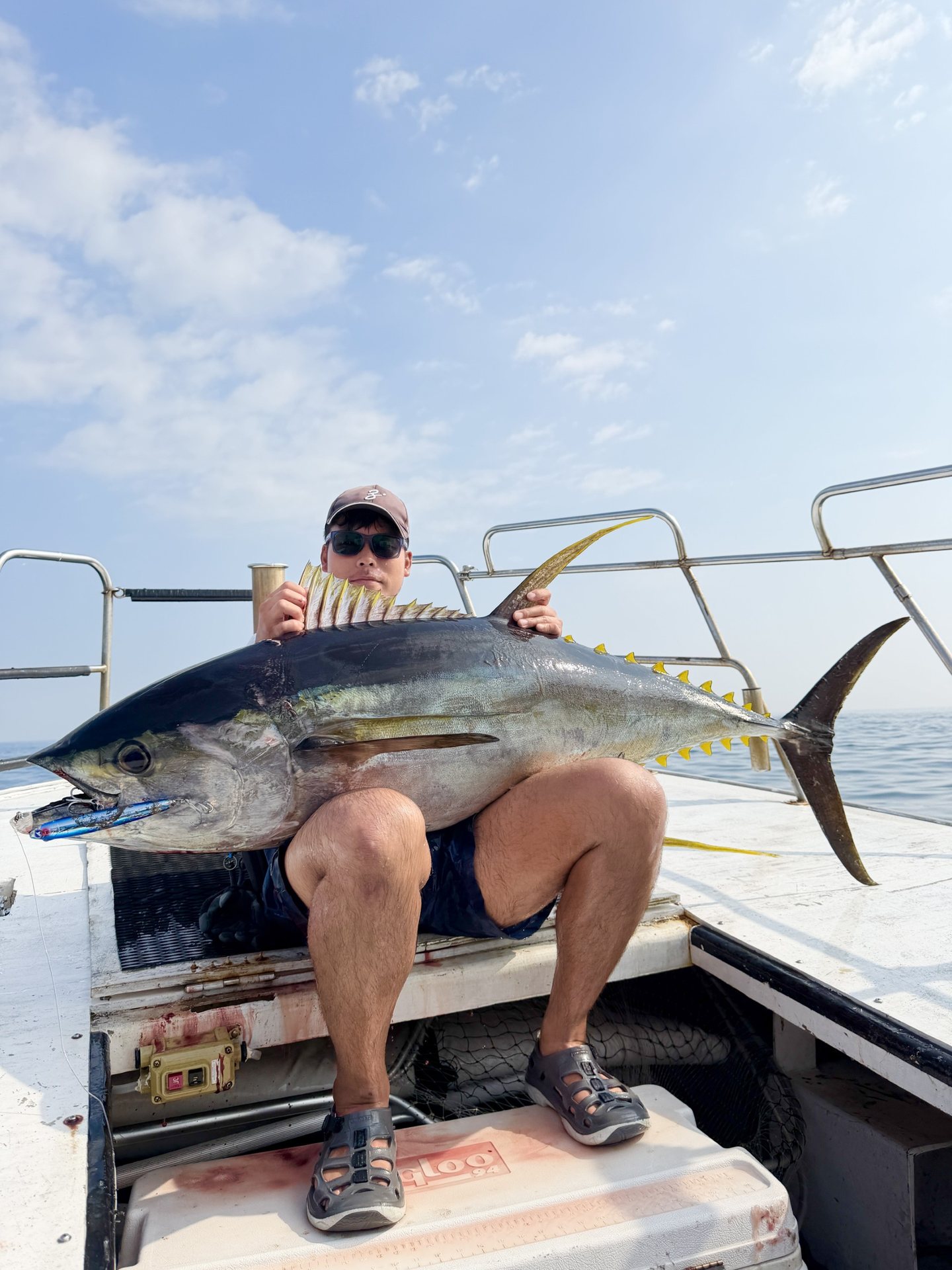 キハダマグロを膝に乗せる長田晃輔