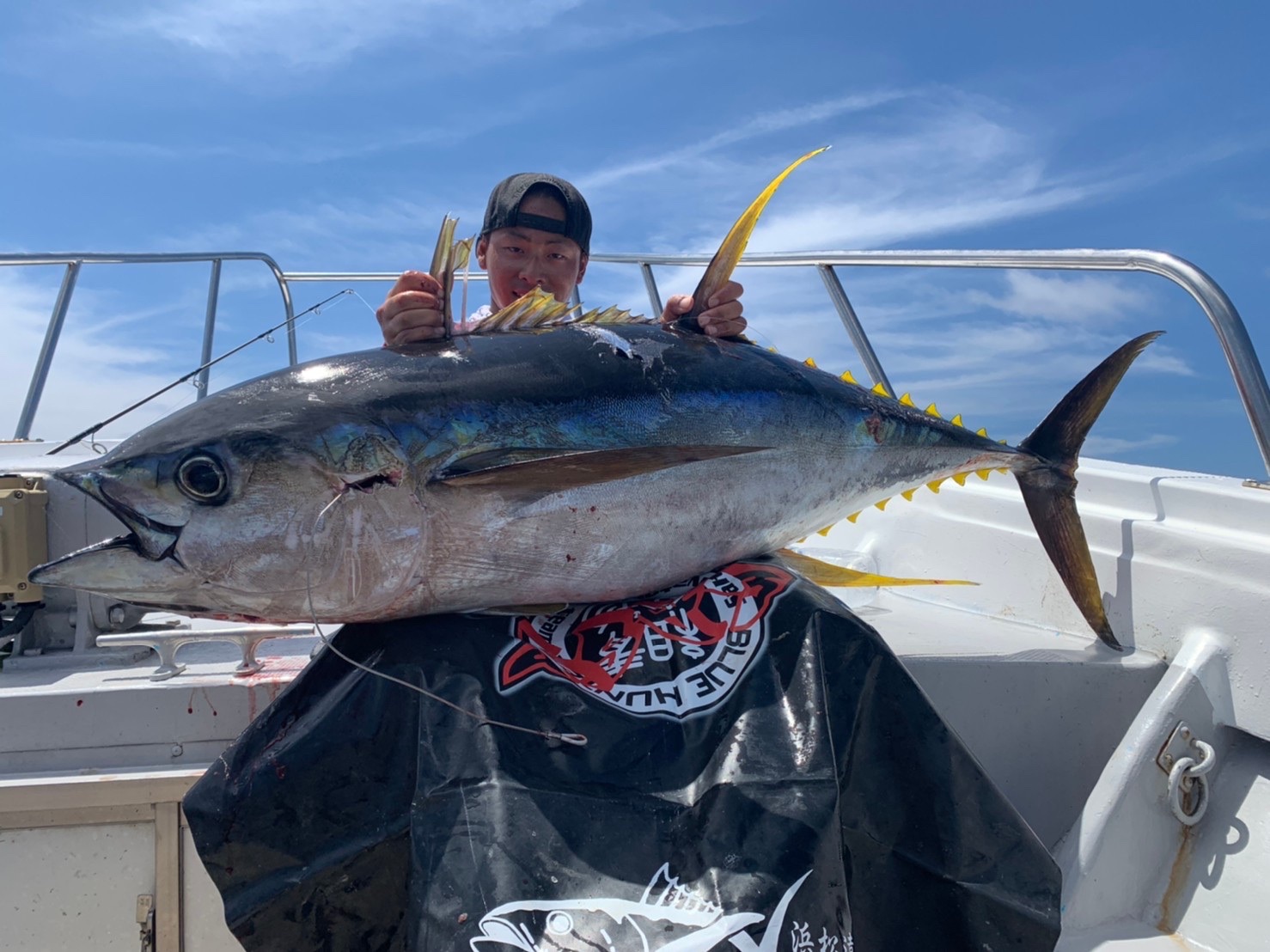 青空のもとキハダマグロを掲げる根木辰吉