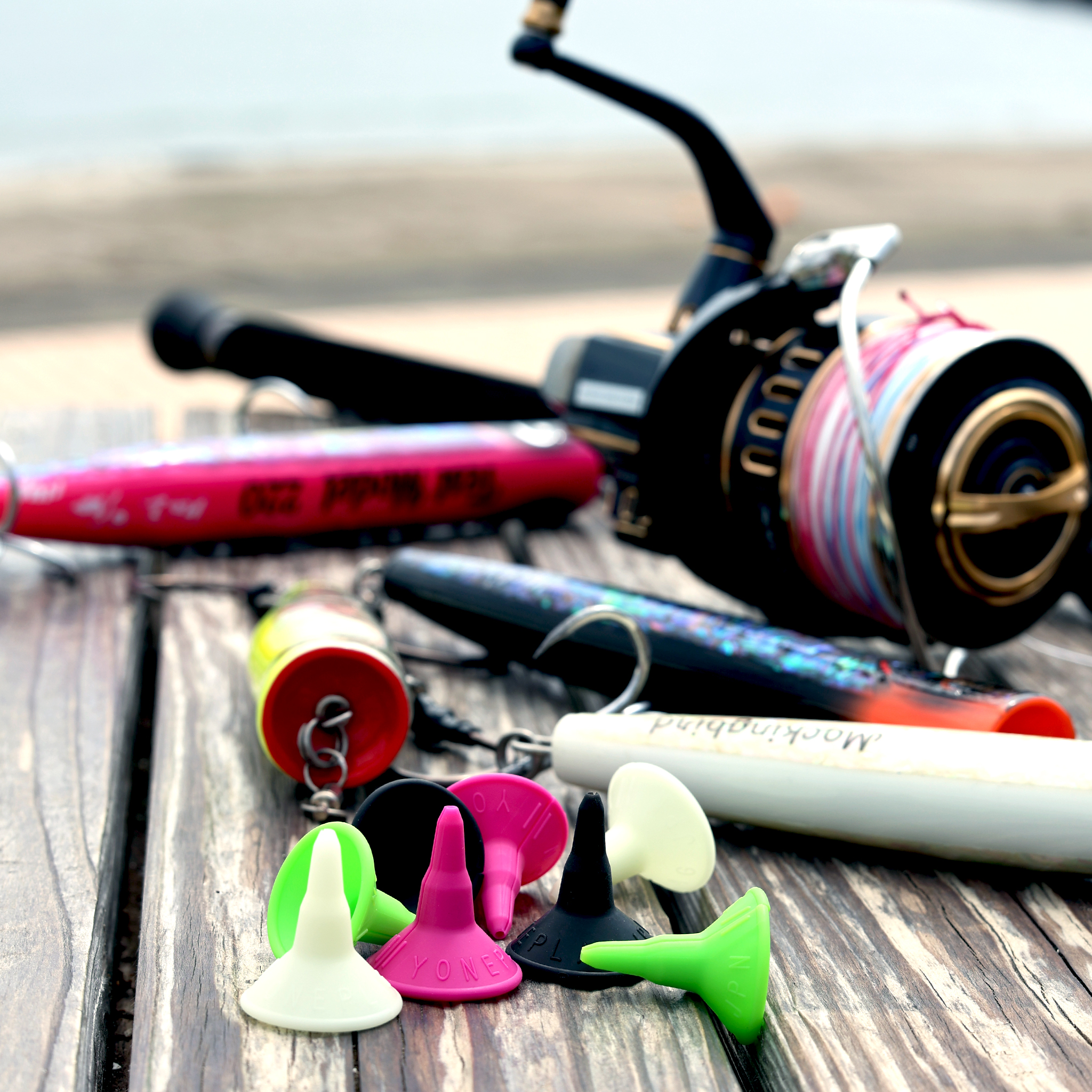 A reel, plug and the four YONEPLAG colors arranged on the deck by the gunwale
